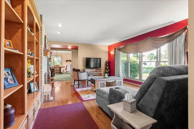 a living room with furniture a flat screen tv and a large window