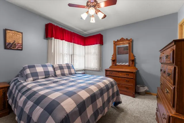 a bedroom with a bed and dresser with window