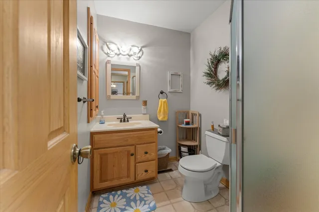 a bathroom with a toilet sink vanity granite and mirror