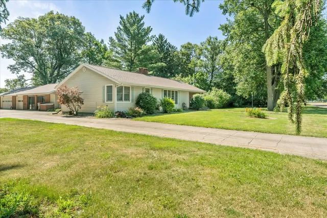 a front view of a house with a yard and trees
