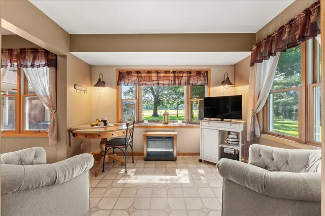 a living room with furniture a flat screen tv and a large window