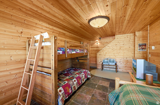 2096 South Aspen Ridge Coalville, UT 84017 - Photo 27 of 44 Wood-paneled room featuring slate tile flooring, a built-in bunk bed structure, and overhead flush-mount lighting