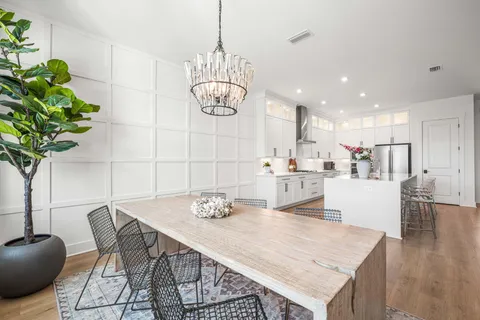 a walk in closet with wooden floor