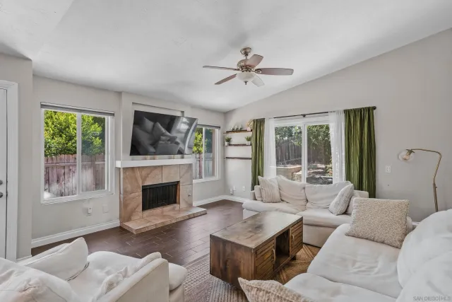 a living room with furniture a fireplace and a floor to ceiling window