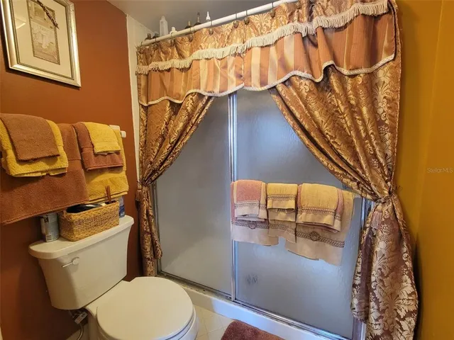 a bathroom with a toilet and a shower curtain