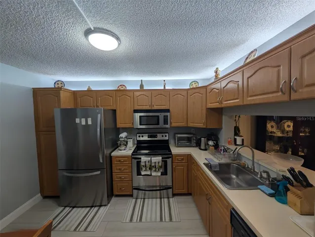 a kitchen with stainless steel appliances granite countertop a refrigerator stove and sink
