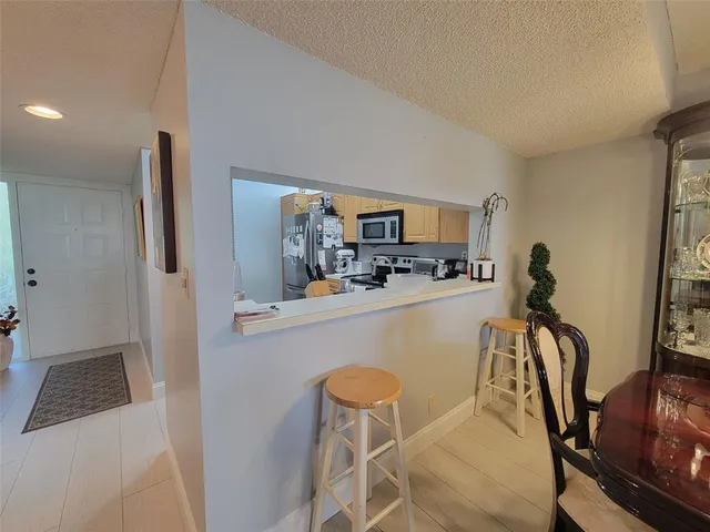 a view of a dining room with furniture and a view of kitchen