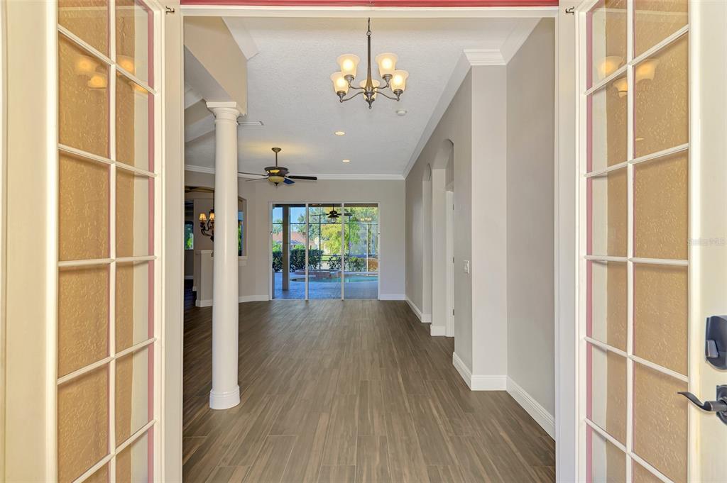 6610 Coopers Hawk Court Lakewood Ranch, FL 34202 - Photo 12 of 97 a view of a hallway with wooden floor and a chandelier