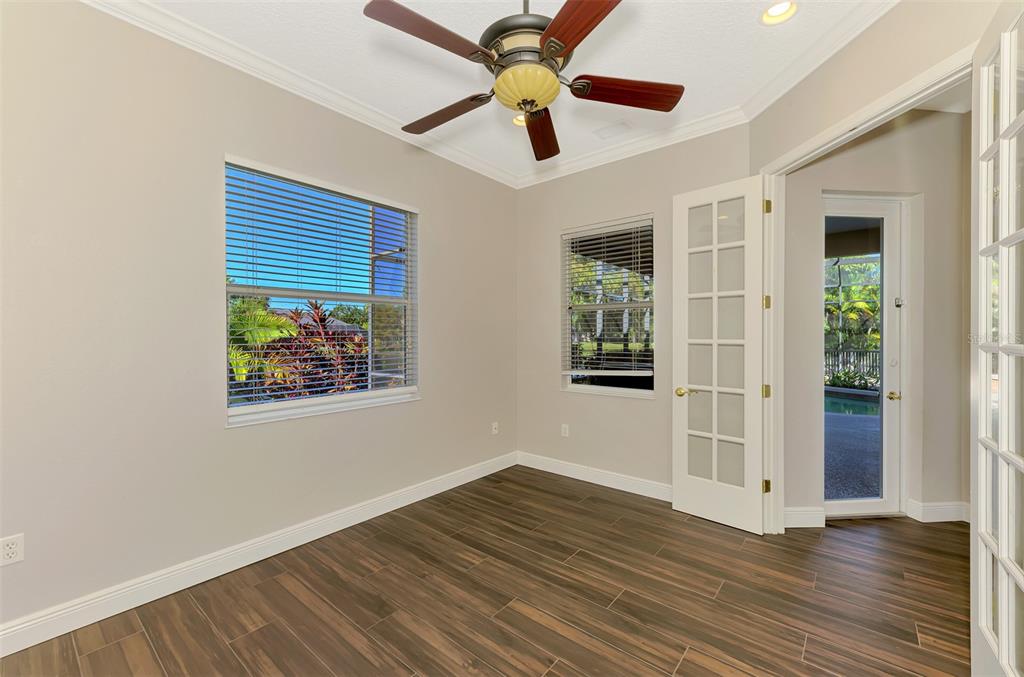 6610 Coopers Hawk Court Lakewood Ranch, FL 34202 - Photo 71 of 97 a view of an empty room with wooden floor and a ceiling fan