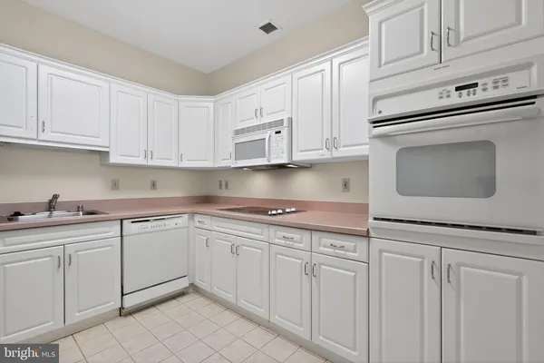 a kitchen with white cabinets granite counter tops and a stove
