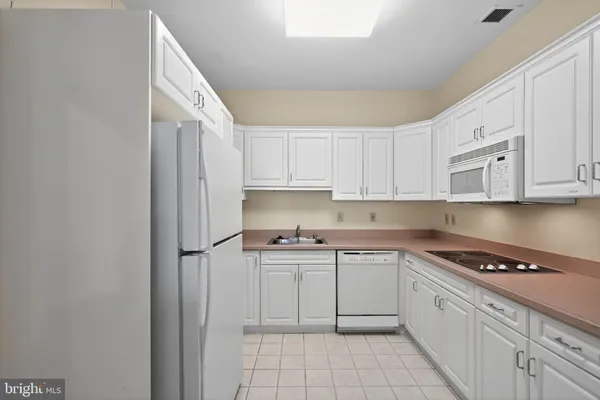 a kitchen with white cabinets stainless steel appliances and a sink