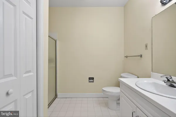 a bathroom with a granite countertop toilet a sink and a mirror