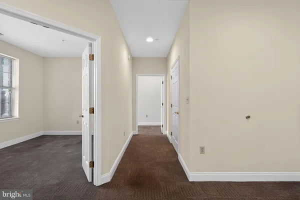 a view of a hallway with a livingroom and a window