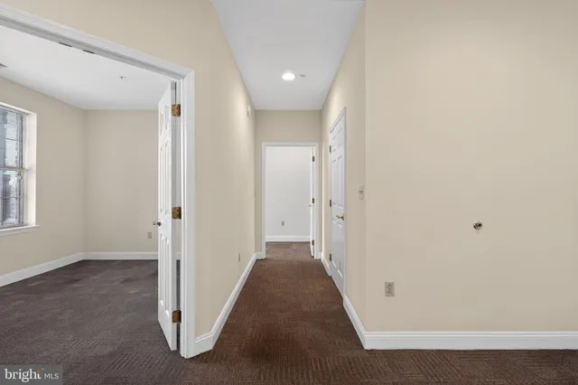 a view of a hallway with a livingroom and a window