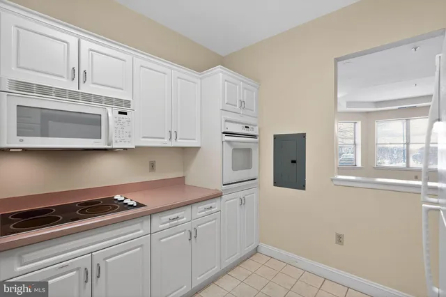 a kitchen with stainless steel appliances granite countertop white cabinets and window