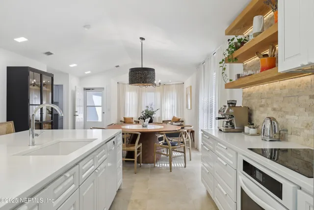 a kitchen with stainless steel appliances a sink a stove and a center island
