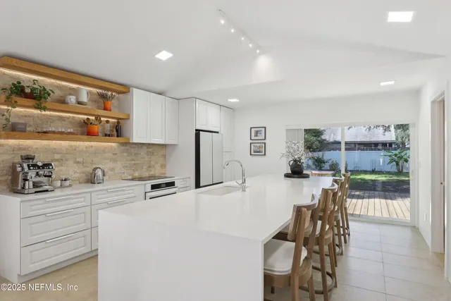 a kitchen with stainless steel appliances kitchen island granite countertop a cabinets and a view of living room