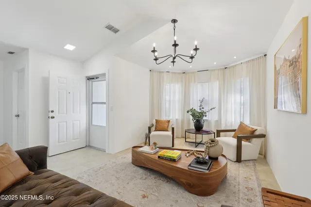 a living room with furniture and a chandelier
