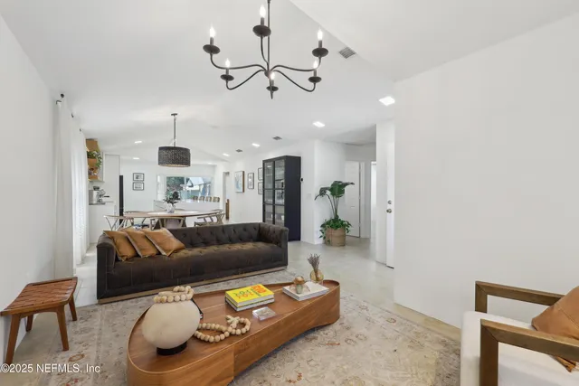 a living room with furniture and a chandelier