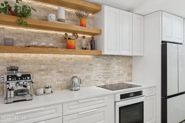 a kitchen with white cabinets and a stove