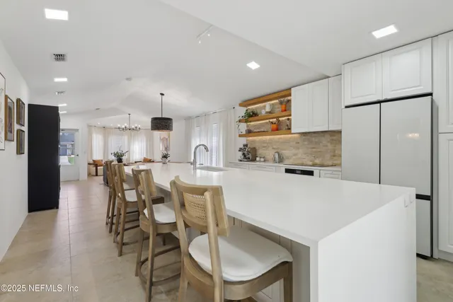 a view of kitchen with refrigerator stove dining table and chairs