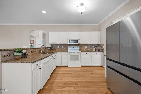 a kitchen with stainless steel appliances a refrigerator and wooden floor