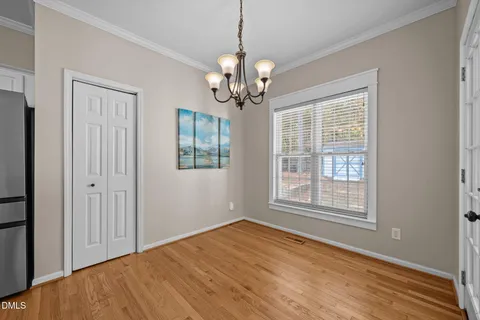 a view of a livingroom with a fireplace a ceiling fan and wooden floor