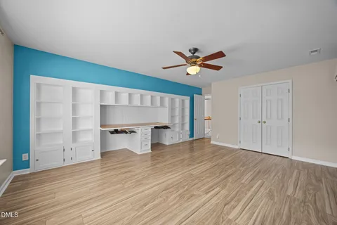 a view of backyard with large trees and wooden fence