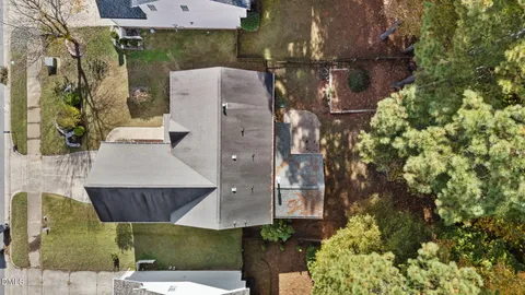 a aerial view of a house with a yard and large trees
