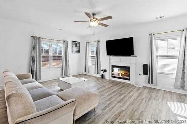 a living room with furniture a flat screen tv and a fireplace