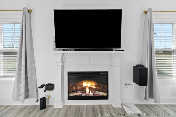 a living room with furniture a flat screen tv and a fireplace