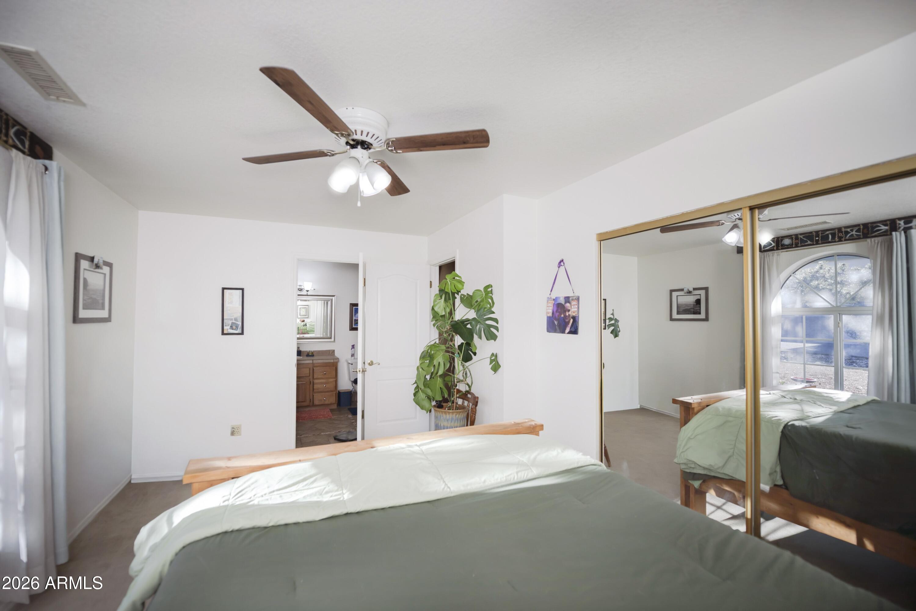 11160 Pima Road Dewey, AZ 86327 - Photo 16 of 58 a bedroom with a bed and ceiling fan