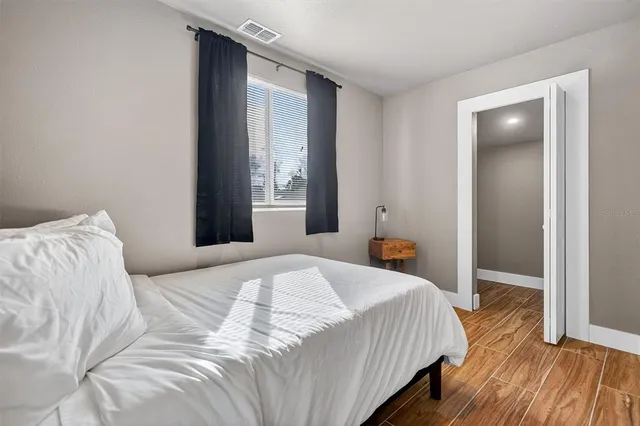 a bedroom with a bed and wooden floor
