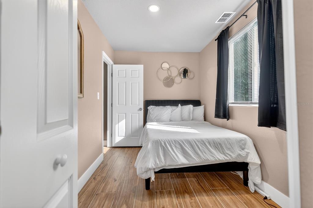 917 Mack Avenue, Unit 2 Orlando, FL 32805 - Photo 18 of 19 a bedroom with a bed and wooden floor