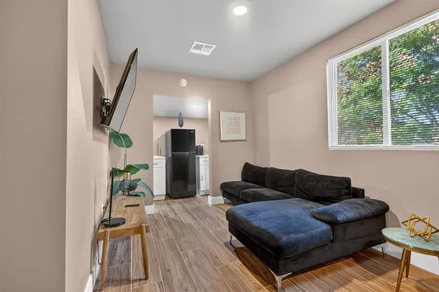 a living room with furniture and a wooden floor