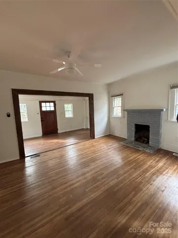 a view of empty room with wooden floor and fireplace