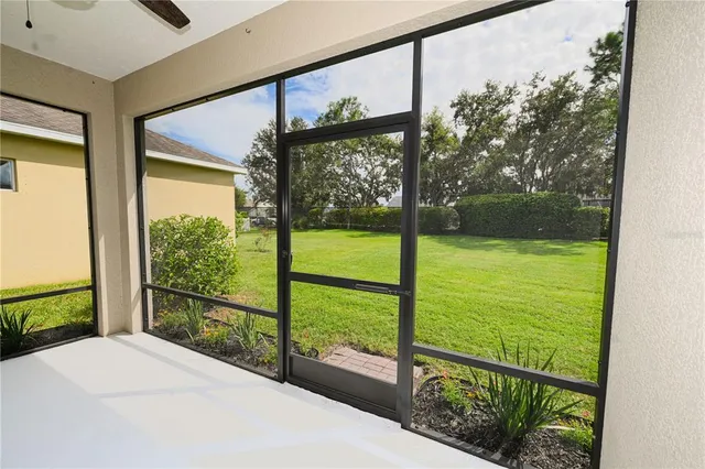 a palm tree sitting in front of a house with a big yard