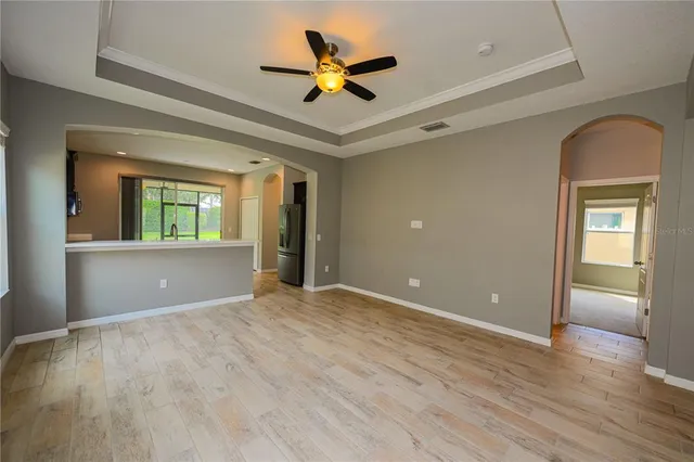 a view of an empty room with a window and a kitchen