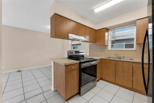a kitchen with stainless steel appliances granite countertop a stove a sink and a refrigerator