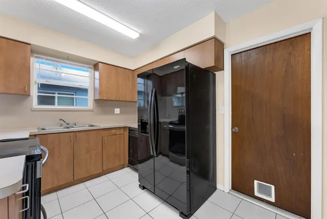 a kitchen with stainless steel appliances granite countertop a refrigerator and a stove top oven