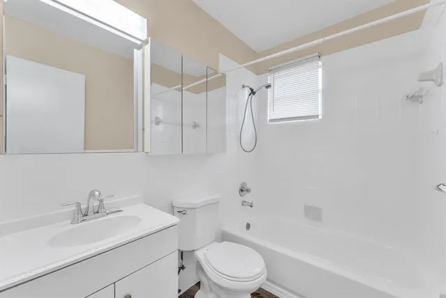 a bathroom with a sink toilet vanity and shower
