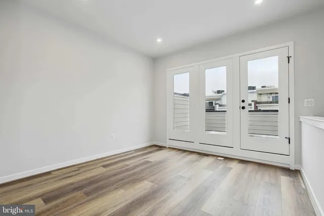 an empty room with wooden floor and white walls