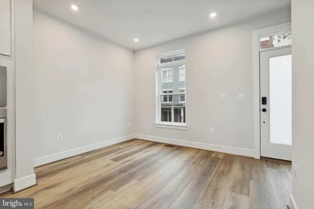 an empty room with wooden floor and windows