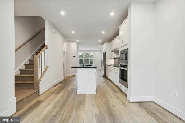a view of kitchen with wooden floor and electronic appliances