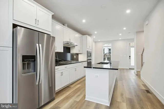 a kitchen with stainless steel appliances a refrigerator sink and microwave