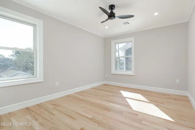 an empty room with a window and a ceiling fan