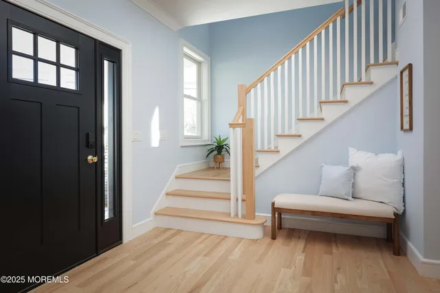 a view of entryway and hall with wooden floor