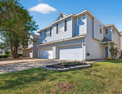 a front view of a house with a yard and trees