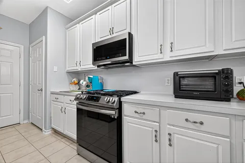 a kitchen with stainless steel appliances granite countertop a stove microwave and cabinets