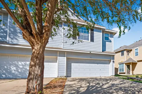 a front view of a house with a tree